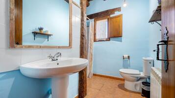 Ein Badezimmer mit Waschbecken, Toilette und Duschbereich.