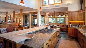 A spacious kitchen with a large island, wooden cabinets, and pendant lighting.