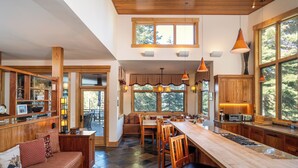 A spacious kitchen with a long island, wooden cabinetry, and a large window providing natural light.