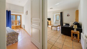 A room with a bed, a chair, a table, a sofa, and a lamp. - Apartment 'Les Gentianes' with Mountain View and Wi-Fi (Val-Cenis)