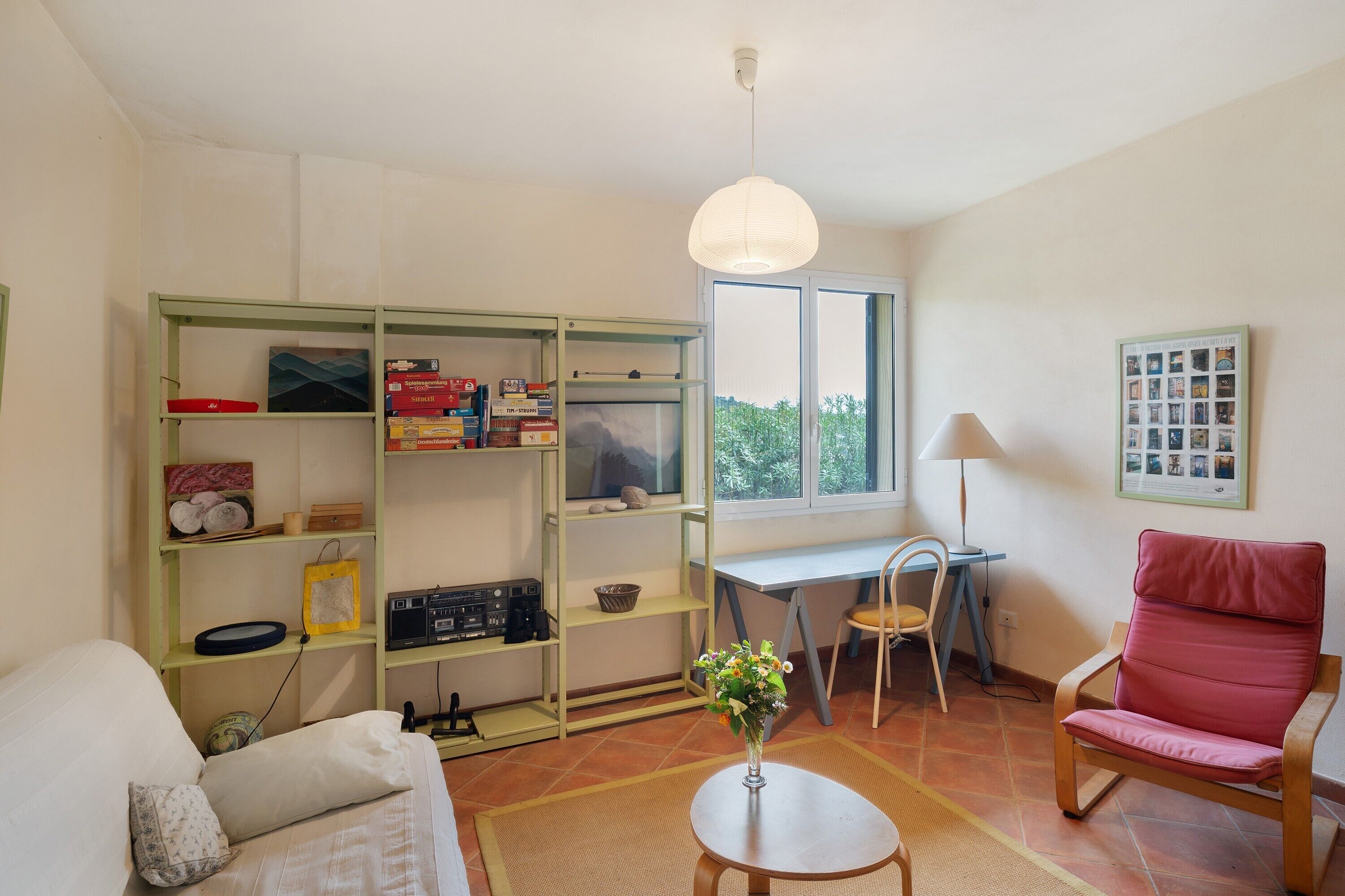 A room with a bed, a desk, a chair, a bookshelf, a lamp, and a window.