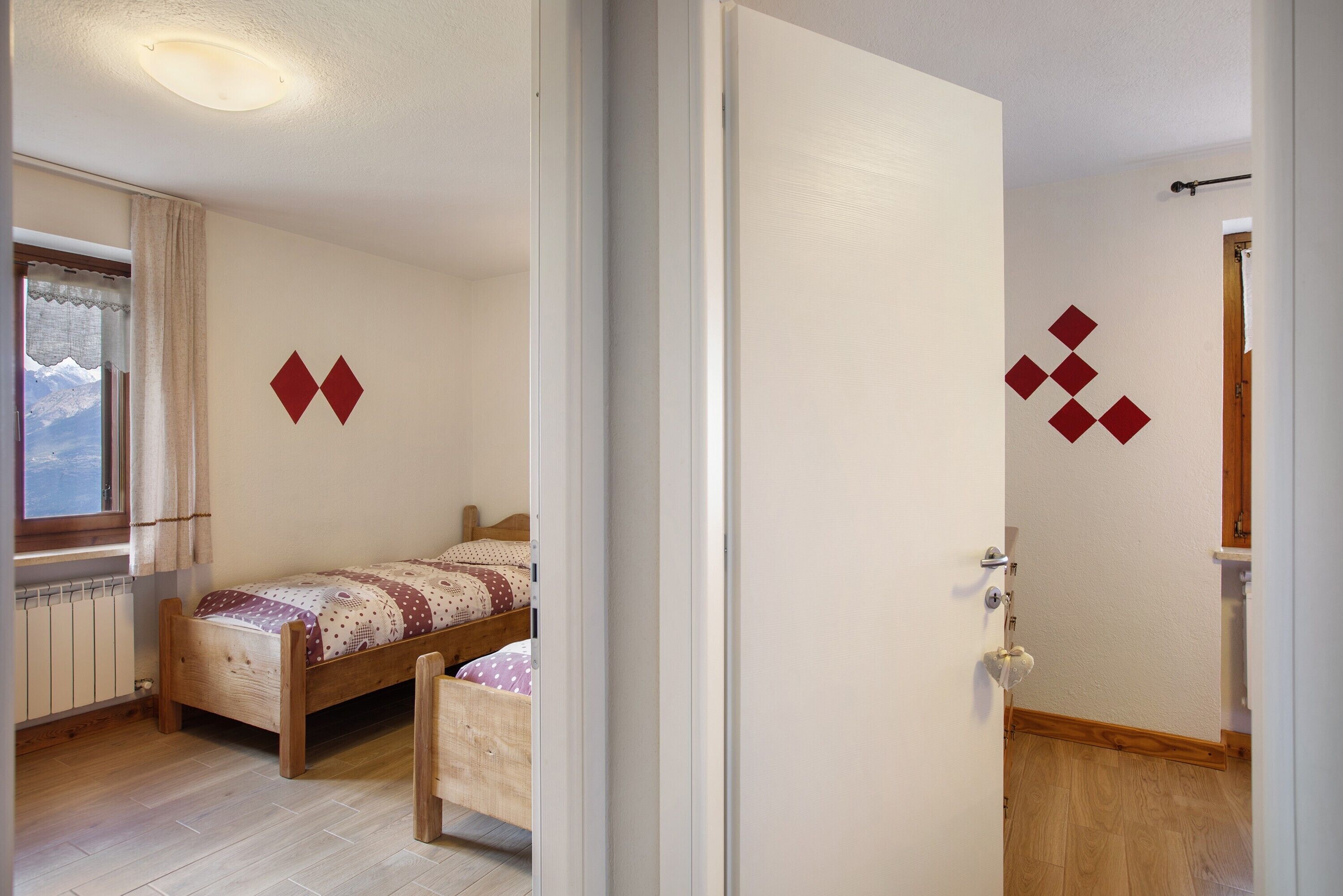Een slaapkamer met een houten bed, een radiator en een raam met gordijnen.