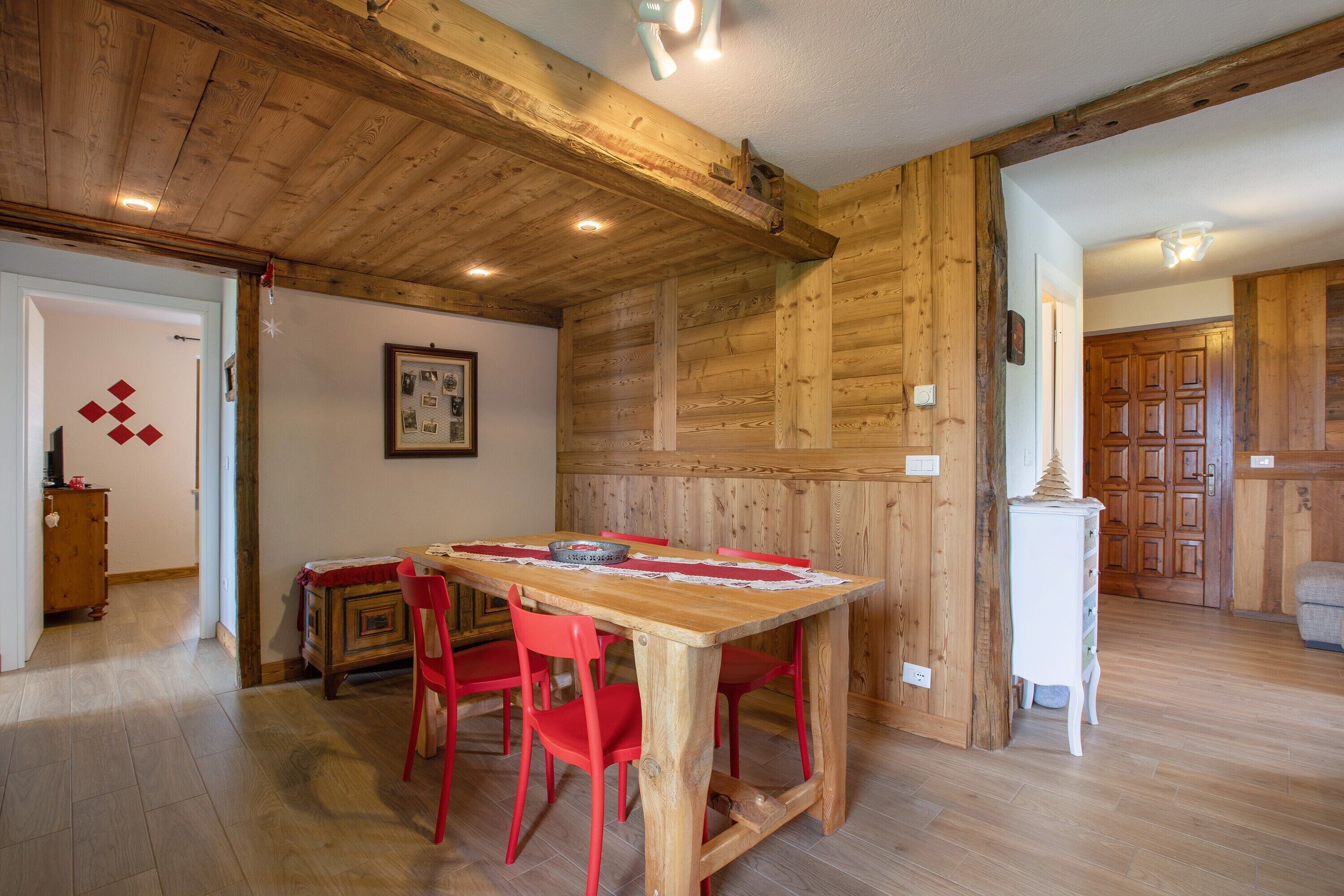 Une salle à manger en bois, avec une table et des chaises, des murs en bois et un plancher en bois.