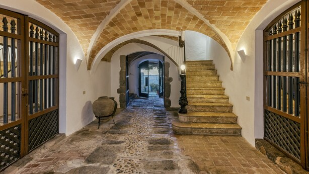 A stone-floored corridor with arched ceilings and wooden gates. - Apartment 'Apartaments Can Gibert - Aiguamolls' with Private Terrace, Wi-Fi and Air Conditioning (Castelló d'Empúries)