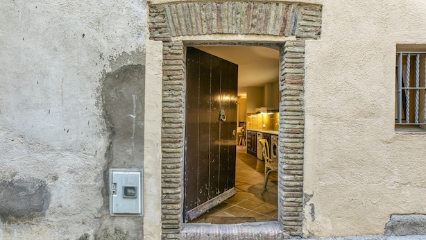 A doorway with a stone archway leading to an interior space.