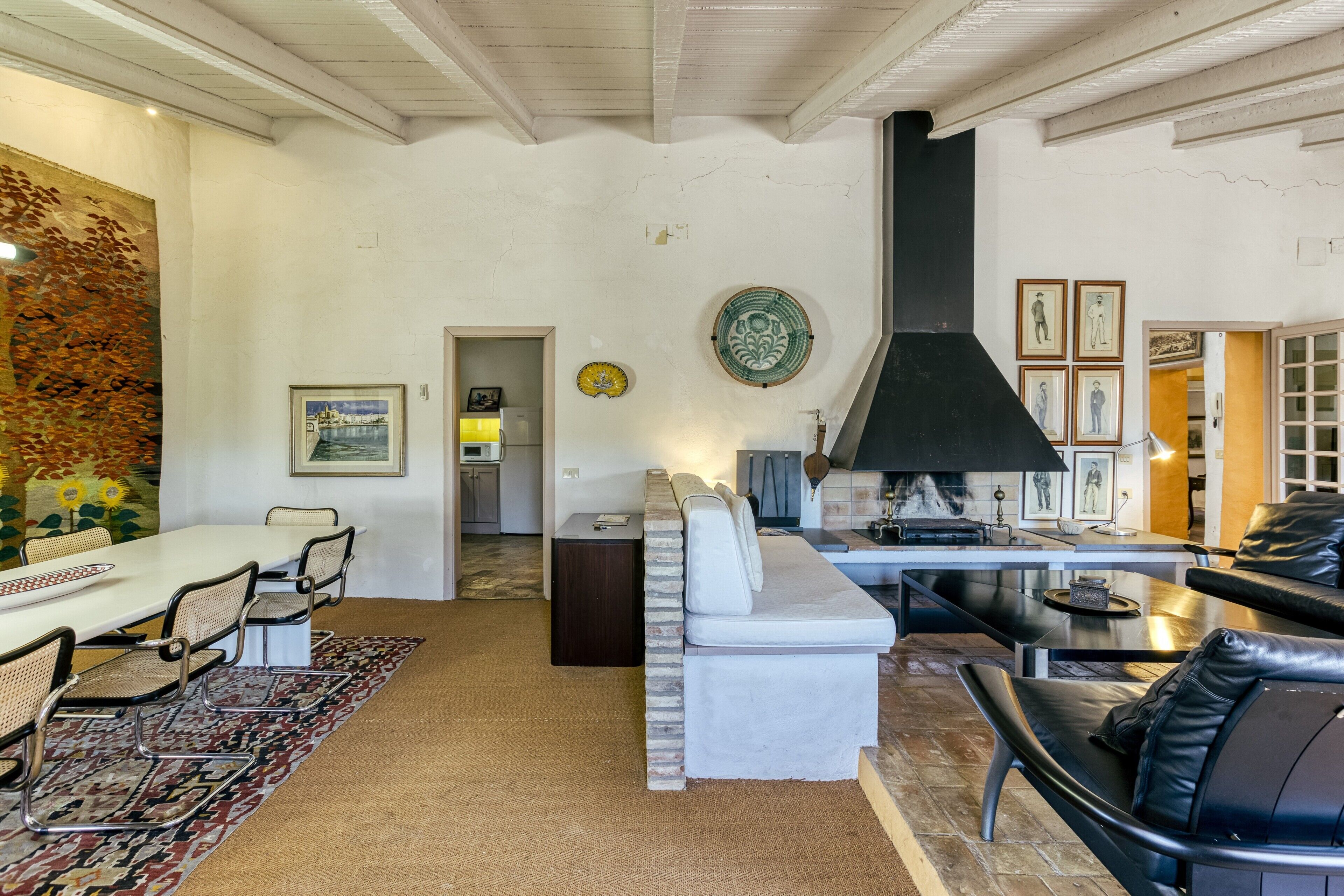 A spacious living area with a dining table, sofa, and fireplace.