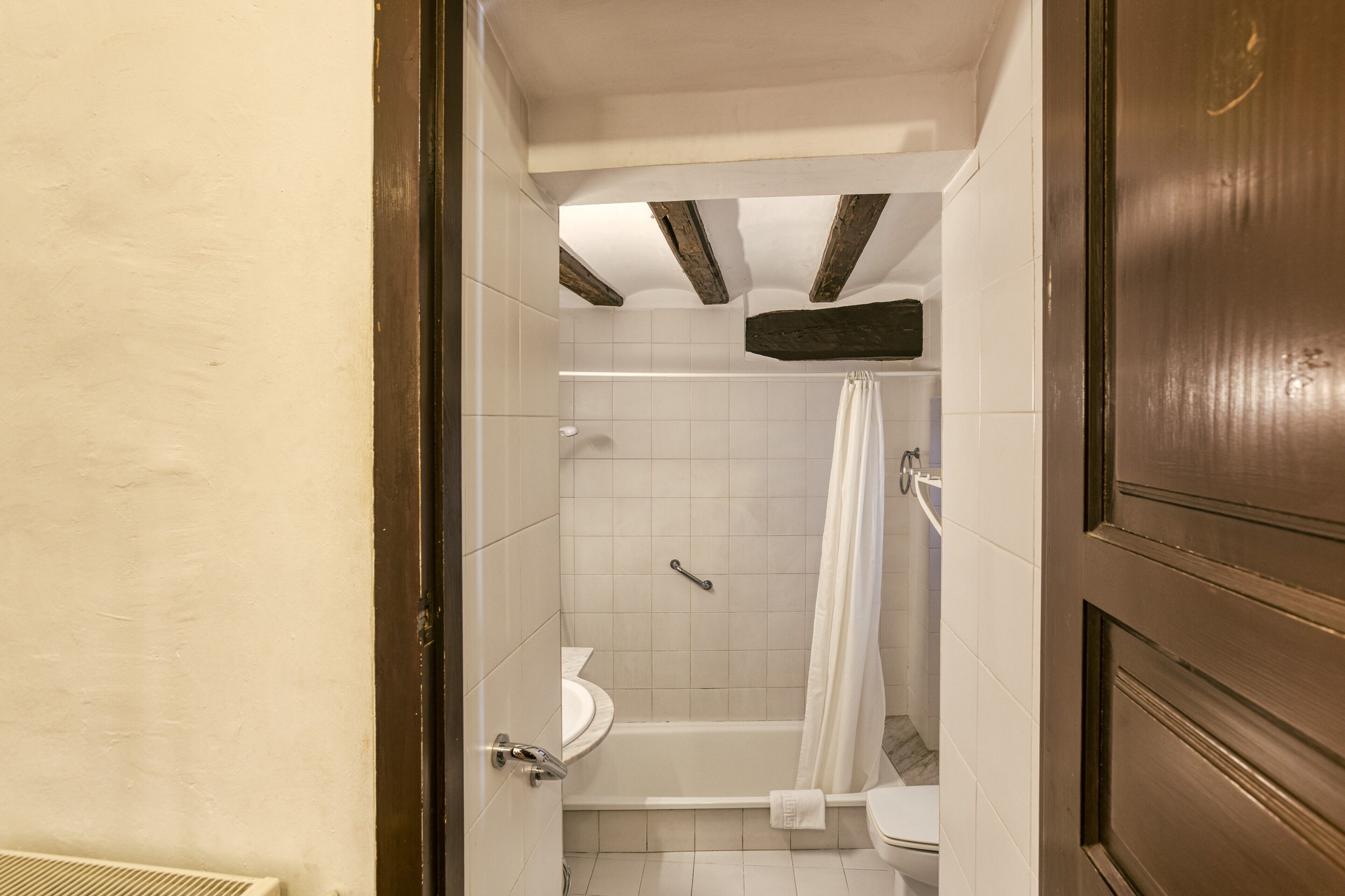 Une salle de bain équipée de toilettes, d’une baignoire et d’un rideau de douche.