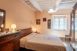 A bedroom with a bed, dresser, lamp, and a window with curtains. - Holiday Home 'Casa Rosa' with Private Terrace, Private Garden and Wi-Fi (Ruota)