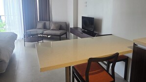 A modern living room with a large table, a sofa, and a TV.