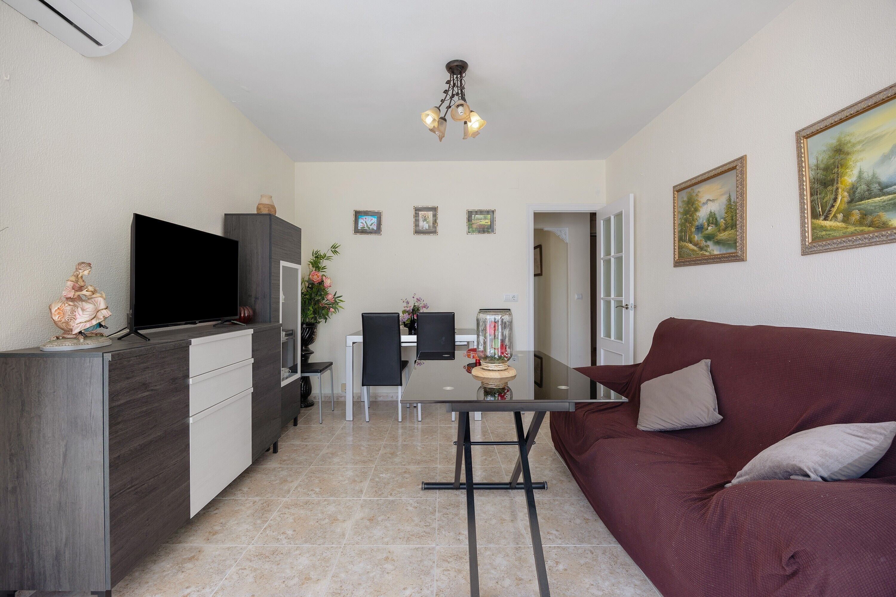 En moderne stue med tv, sofa, spisebord og stole.