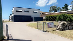 A modern two-story building with a flat roof, large windows, and a gated entrance. - Fish Tales - Absolute Waterfront Toogoom-Sleeps 12-14-Air Con-Wi-Fi-Pets (Toogoom)