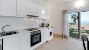 A modern kitchen with white cabinets, a built-in oven, a microwave, and a washing machine. - Holiday Home 'La Casa del Caballo' with Sea Views, Private Pool and Wi-Fi (Adeje)