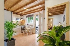 Een keuken met een eethoek, houten plafond en potplanten.