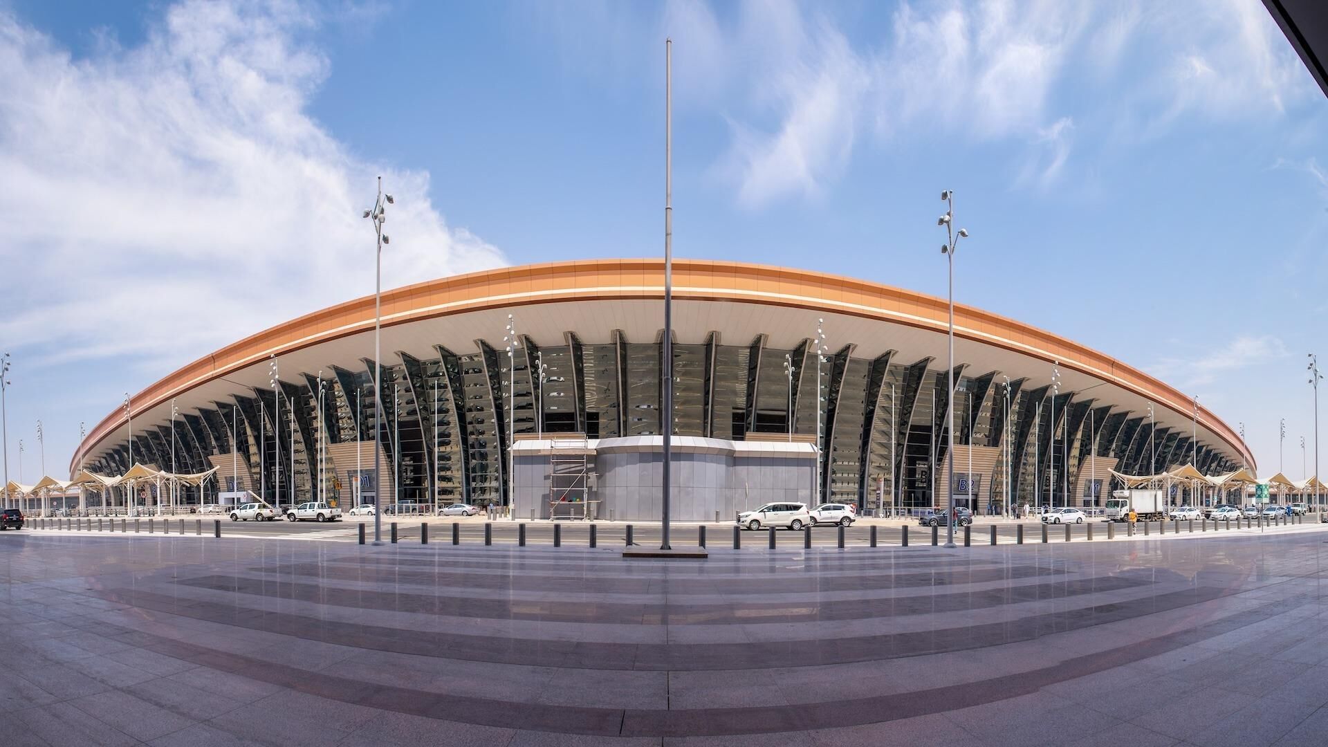 Un estadio grande y moderno con techo curvo y varios niveles de asientos.
