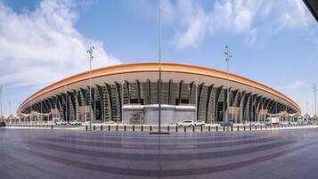 Un estadio grande y moderno con techo curvo y varios niveles de asientos.