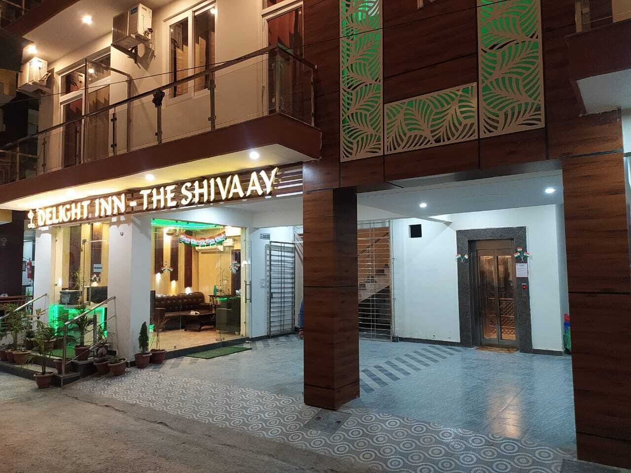 Entrada de un hotel con un letrero que dice 'Delight Inn - The Shiva Ay'.