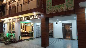 Entrada de un hotel con un letrero que dice 'Delight Inn - The Shiva Ay'.