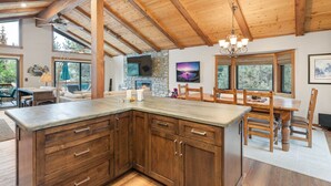 A spacious kitchen with wooden cabinets, a large island, and a stone fireplace. - Edgewater Escape in Dollar Point Tahoe City (Tahoe City)