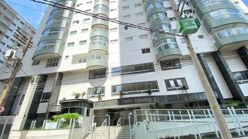 A multi-story building with a modern design, featuring a central entrance with a staircase and a sign that reads "Res. Sanio Expedito X".