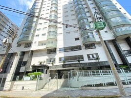 A multi-story building with a modern design, featuring a central entrance with a staircase and a sign that reads "Res. Sanio Expedito X".