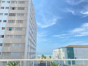 Un edificio de gran altura con varios balcones y vista a la playa.