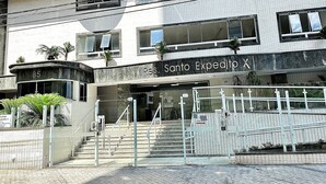 Edifici de diverses plantes amb un rètol que diu "Santo Expedito X" i el número "85" a la façana.