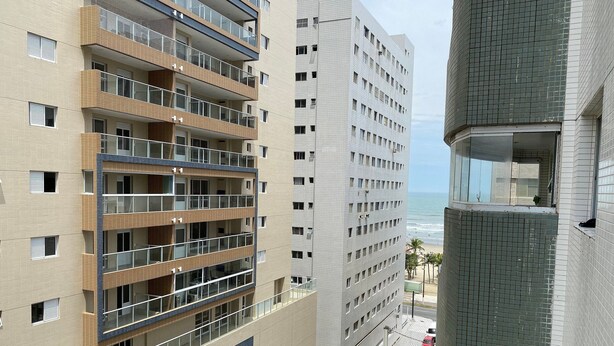 Hotel de diverses plantes amb balcons, vista a la platja i un senyal prominent d' 'Acqua Mare'.