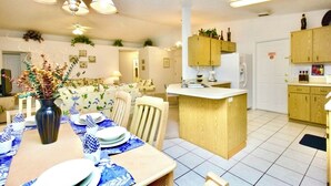 A modern kitchen with wooden cabinets, a central island, and a dining area with a table set for four. - Ref 317. Stunning villa with own pool near Disney (Four Corners)