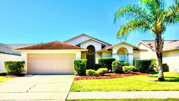 A single-story house with a garage, a front door, and a small front yard with a palm tree and trimmed bushes. - Ref 317. Stunning villa with own pool near Disney (Four Corners)