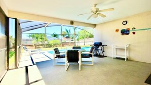 A sunlit room with a ceiling fan, a pool view, and a barbecue grill. - Ref 317. Stunning villa with own pool near Disney (Four Corners)