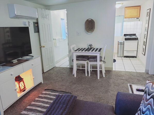 A compact living space with a TV, a small dining table, a kitchen area, and a cozy seating area. - Table Mountain Retreat (Golden)