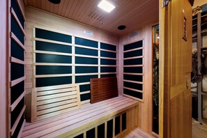 A sauna room with wooden benches and slatted walls. - Group Retreat with Hot Tub, Gym, Sauna, and Fire Pit (Englewood)