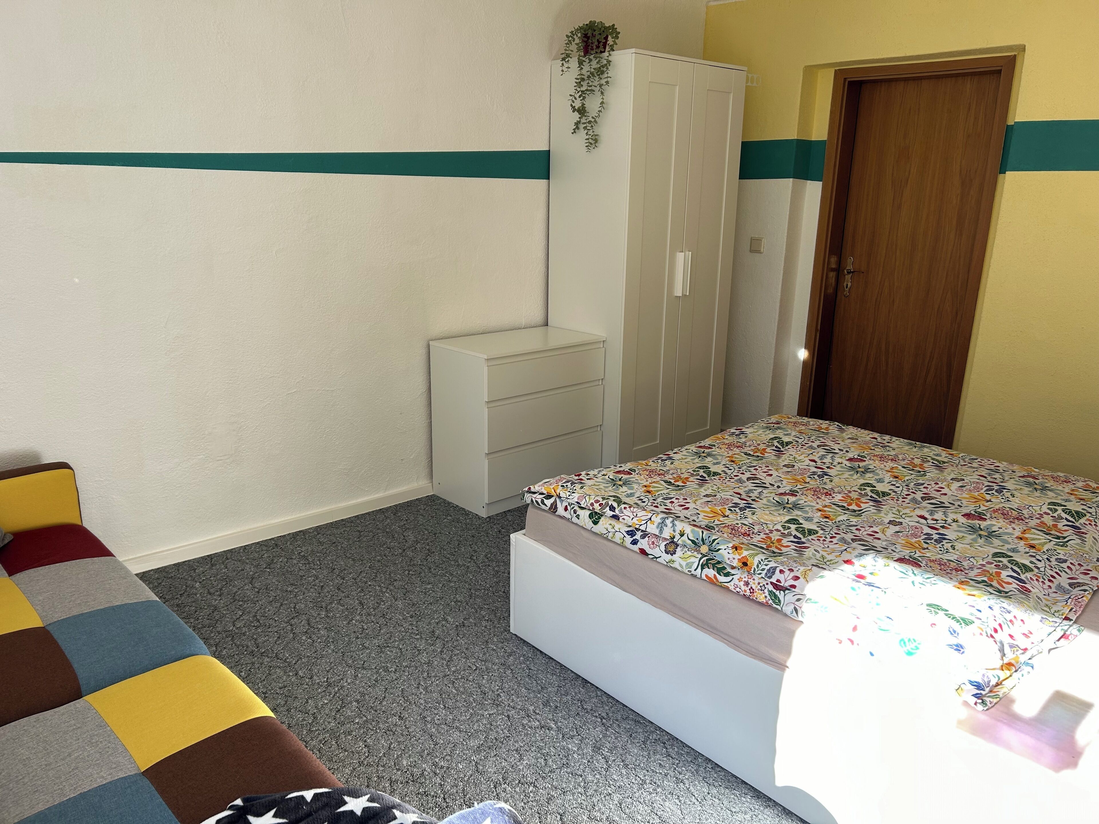Une chambre à coucher comprenant un lit, une armoire, une table de chevet et un canapé.