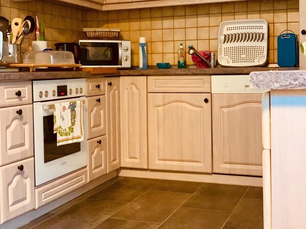 A kitchen with white cabinets, a Bosch oven, a microwave, and a dishwasher.