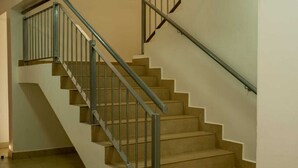 Een trap met metalen leuningen en beige treden.