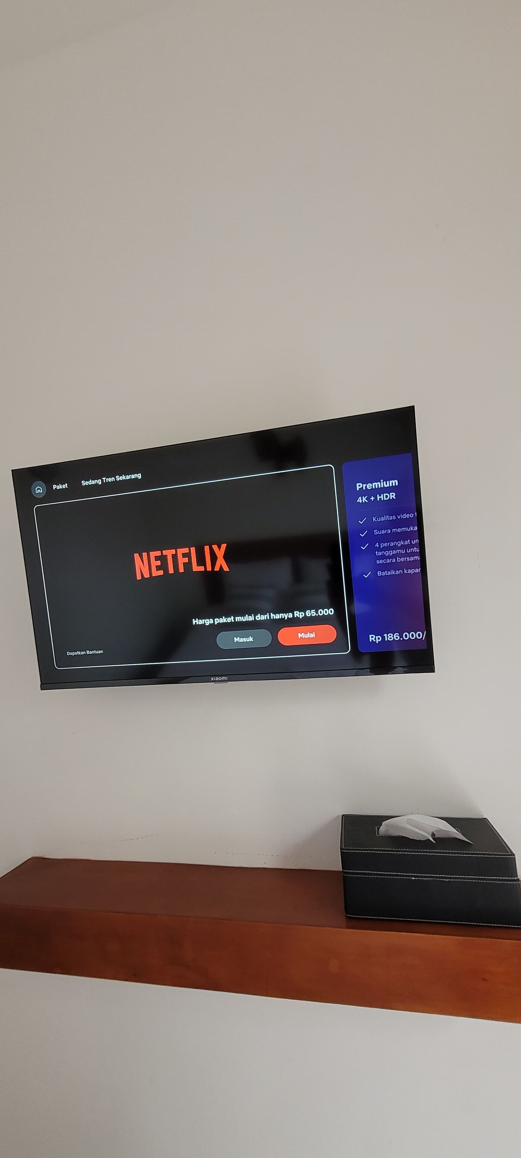 Un televisor mostrando la interfaz de Netflix con un precio de Rp 65,000 por un paquete.