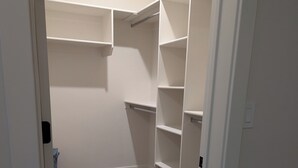 A walk-in closet with wooden flooring and white walls. - Charming 2-bedroom apartment with WiFi , AC and Heating in serene Enterprise (Enterprise)