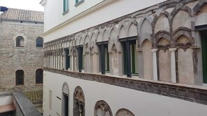 A building with a stone facade, arched windows, and a balcony. - La Maison Bouganville charming guest house in the city center of Salerno (Salerno)