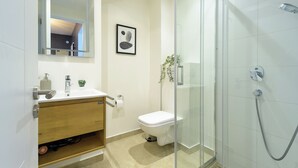 Une salle de bain moderne équipée de toilettes, d’un lavabo et d’une douche.