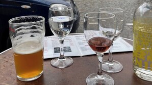 A table with glasses of beer and wine, a newspaper, and a bottle of beer. - Charming apartment (Paris)