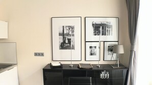 A modern hotel room with a black desk, framed photographs on the wall, a black chair, and a lamp. - Old Town Market Sqr. View-Self Check in 24h-VAT incl. (Wrocław)