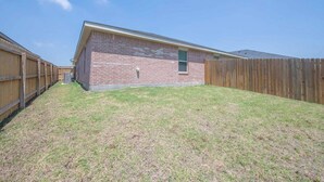 A single-story brick building with a fenced backyard. - Your Getaway in Temple (Temple)