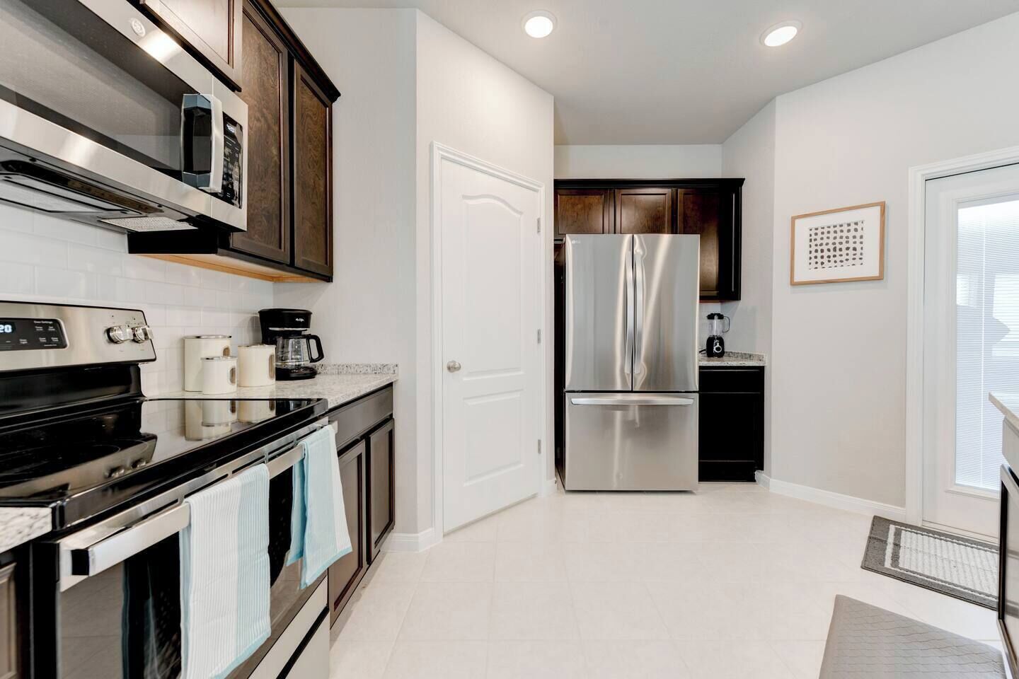 A modern kitchen with stainless steel appliances, a coffee maker, and a refrigerator.