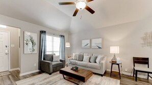 A living room with a ceiling fan, two sofas, a coffee table, and a lamp. - Minute from Baylor Scott & White in Temple (Temple)
