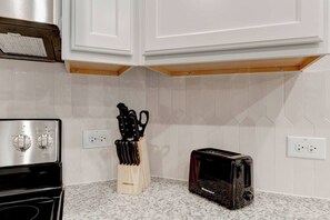 A kitchen with white cabinets, a granite countertop, a toaster, and a knife block. - Spacious 4 Bedroom House in Temple with 5 Beds (Temple)