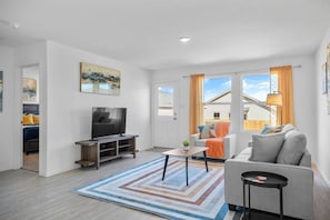 A modern living room with a television, sofa, and coffee table.