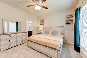 A bedroom with a bed, dresser, ceiling fan, and artwork on the walls. - 5 Beds Home for your workers (Temple)