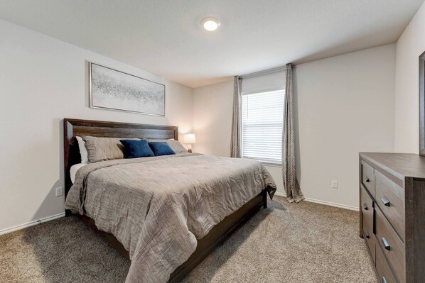 A bedroom with a bed, a nightstand, a dresser, a ceiling light, and a window with curtains. - 4 Bedrooms in Center of Temple (Temple)