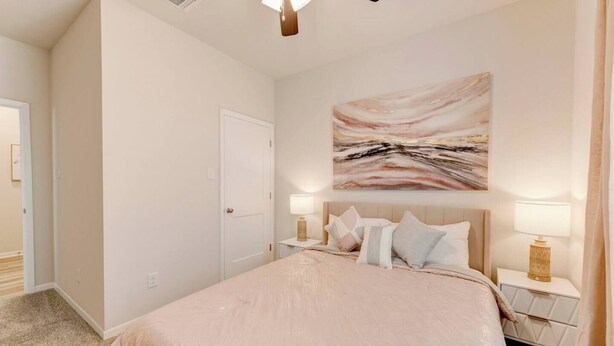 A bedroom with a bed, nightstands, a painting, and a door. - Spacious Modern 5 beds House in Troy (Troy)