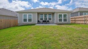A two-story house with a covered patio, a fenced backyard, and a clear sky. - Spacious Modern 5 beds House in Troy (Troy)